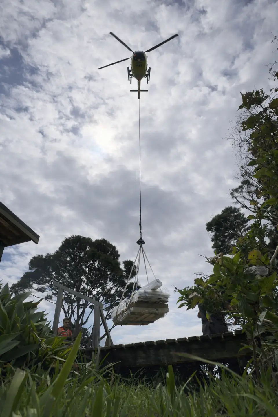 Helicopter lifting building materials onto a remote site