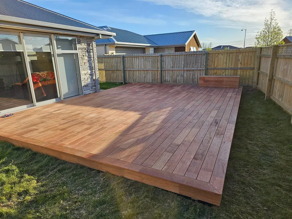 Newly built hardwood deck in a fenced backyard