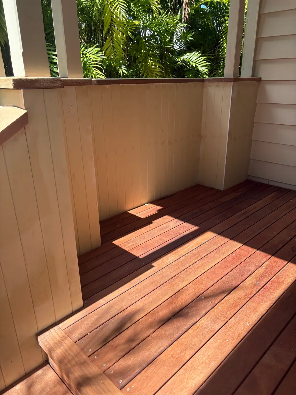 Hardwood porch landing between painted weatherboard walls