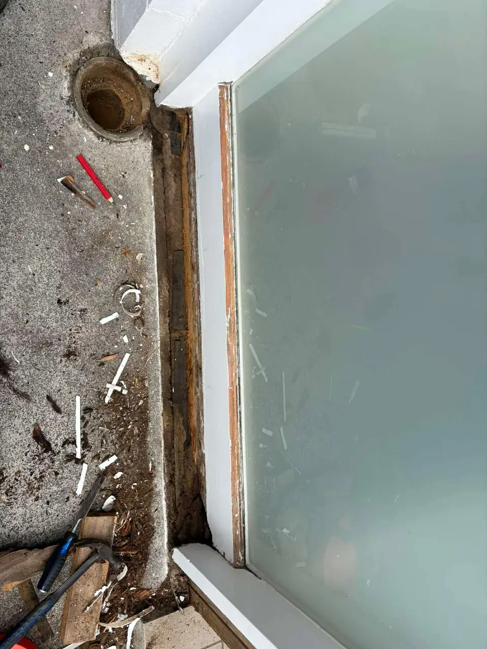 Rotten timber at the base of a sliding door before repair