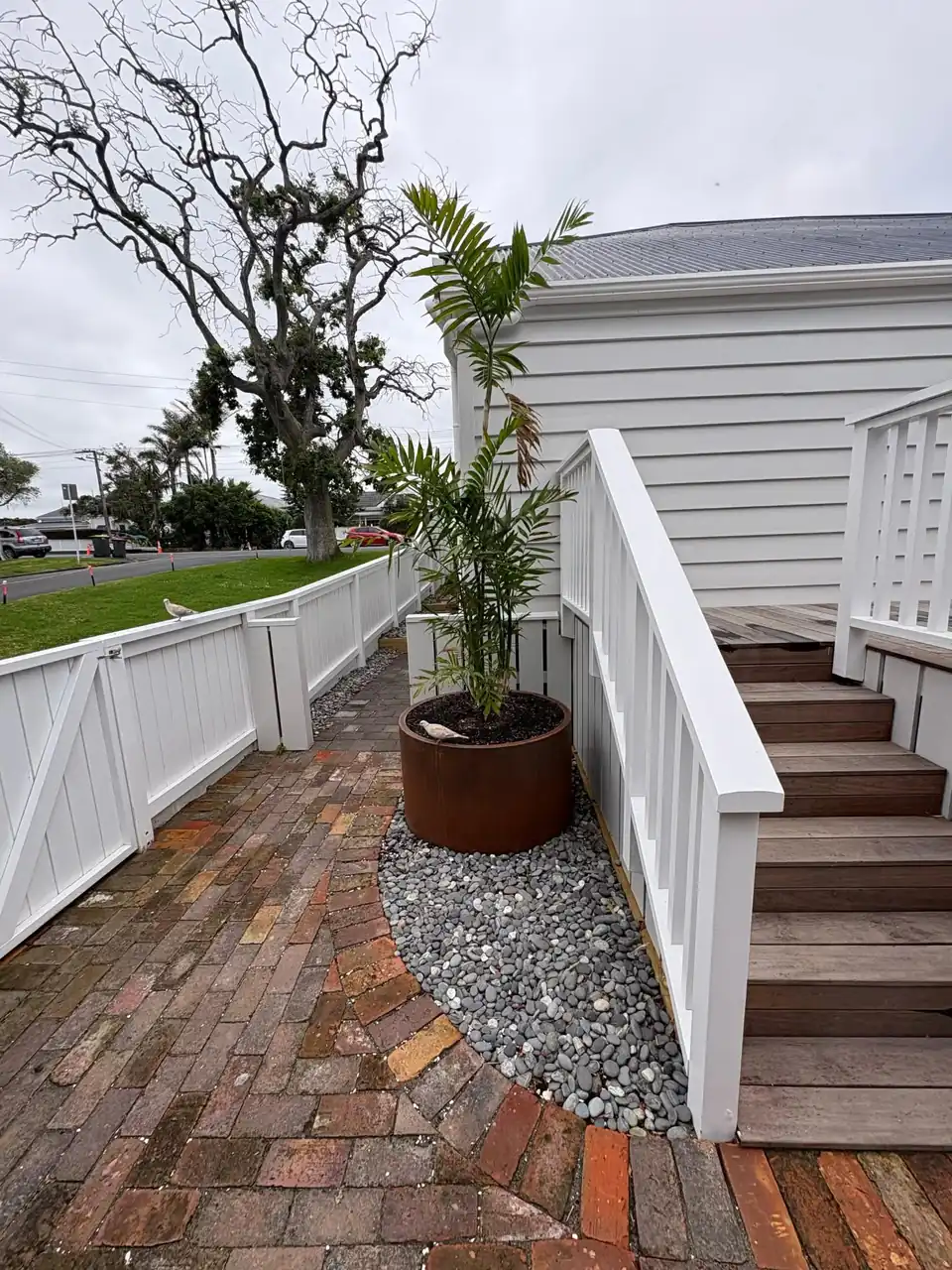 New timber stairs and balustrade beside a curved brick path